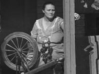 Spinning wheel and hooked rugs on doorstep