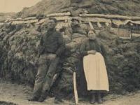 man and woman by hut