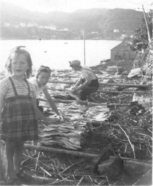 women drying fish with child