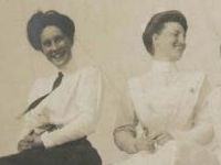 women sitting on rock laughing