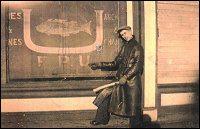 Randolph Tulk pointing to the FPU insignia embossed on the Fishermen's Union Trading Company store blind at Port Union.