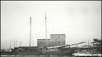 Fishermen's Union Trading Company sealing plant with one of the company�s schooners in foreground.