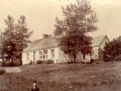 Boy in front of a farm house