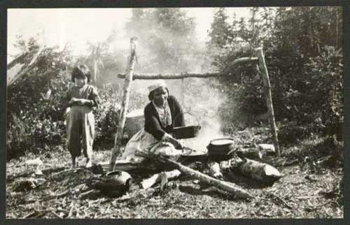 Innu Woman Cooking a Meal over a Campfire, Labrador, 1930