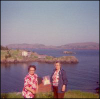 Edna Toope and Aletha [Toope] Spurrell at Ireland's Eye. Llewellyn Toope's abandoned house and twine store in the background